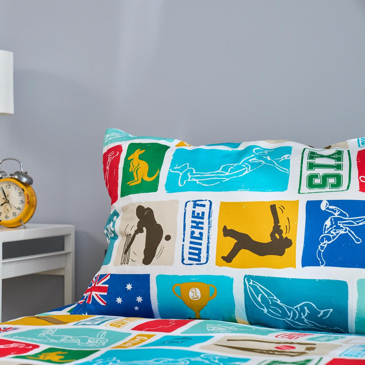 Colorful pillowcase with cricket-themed designs on a bed in a bedroom setting.