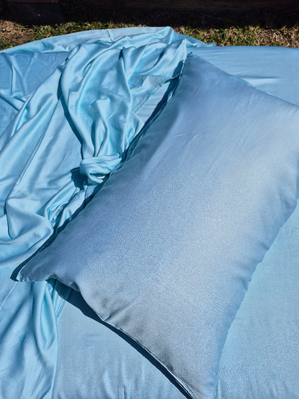 Caribbeanblue bedding set with a pillow on a grassy background