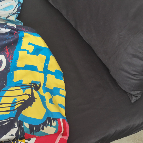 Deep black sheet and pillowcase with colourful quilt cover.