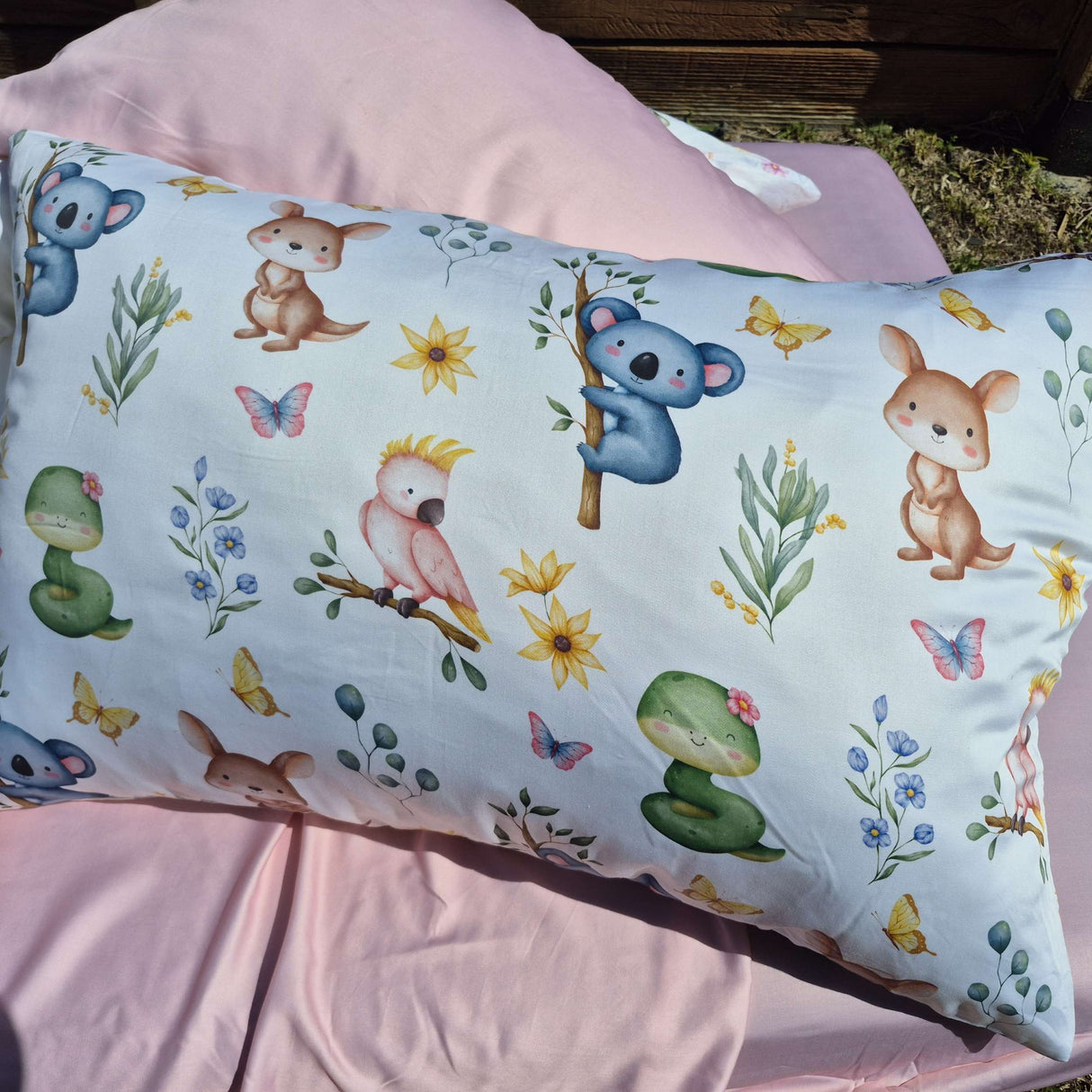 Pillow with animal and nature pattern on a pink background