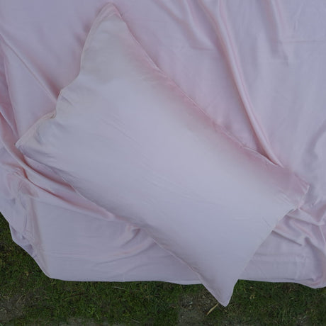 Silky looking Pink pillow on a pink sheet
