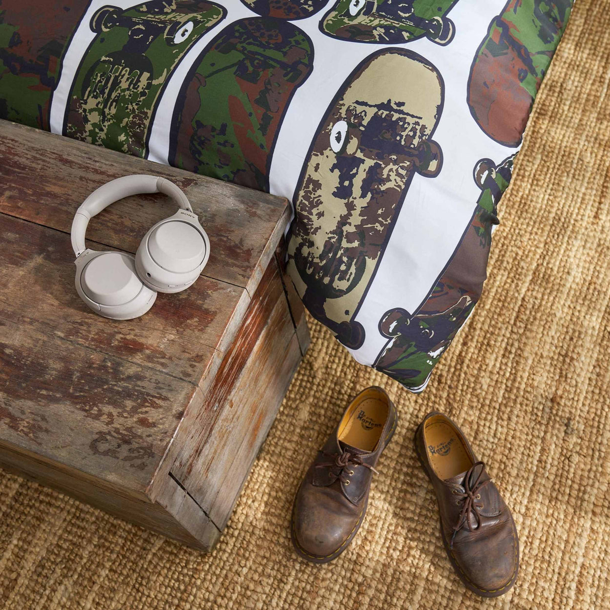 Pair of brown shoes on a textured surface with a wooden block and headphones nearby.