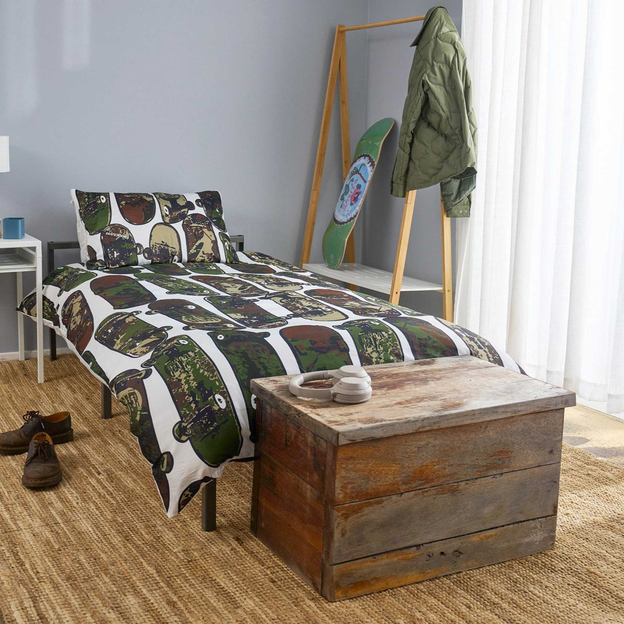 Bedroom with skateboard-themed bedding and wooden chest.