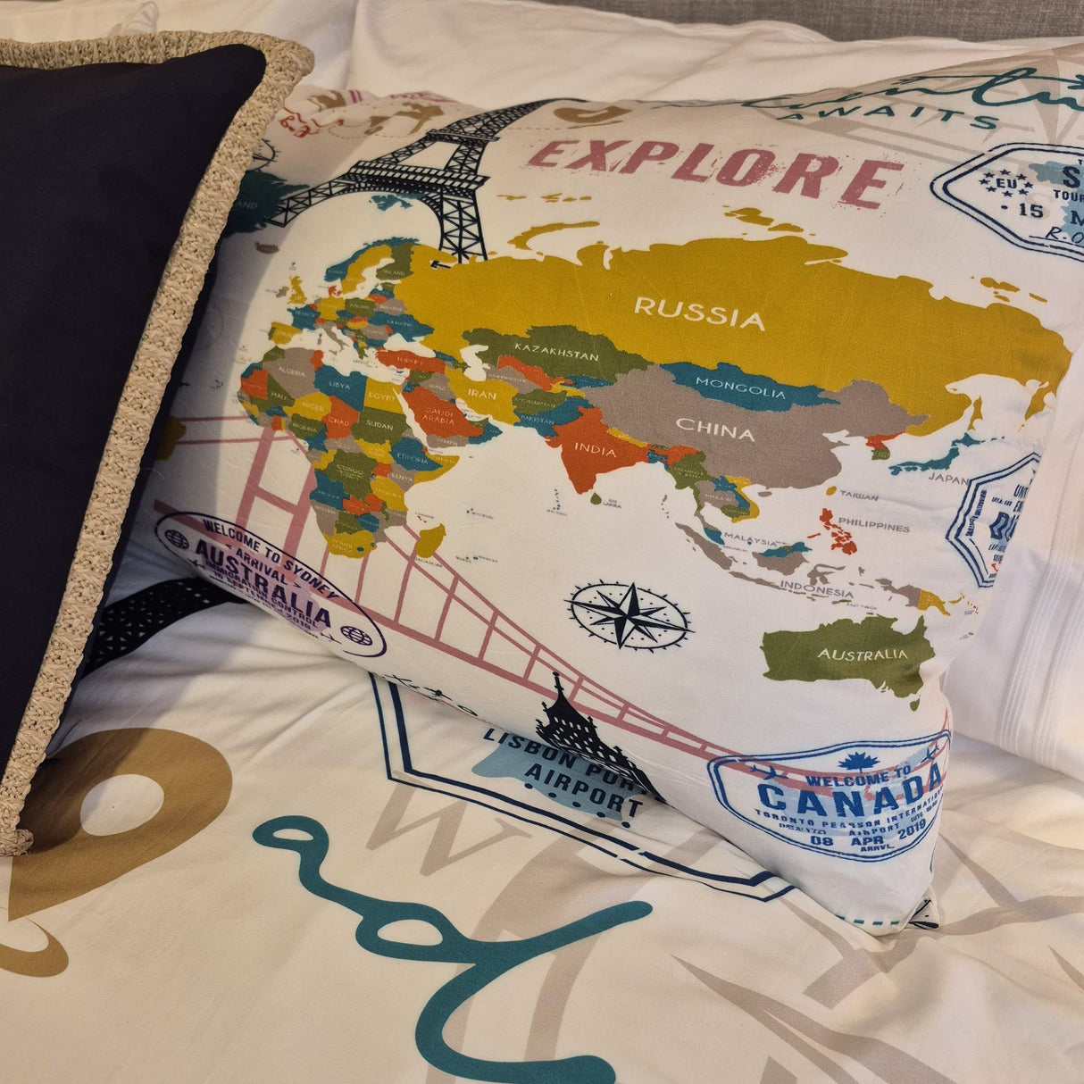 Map-themed pillow with world map design on a bed