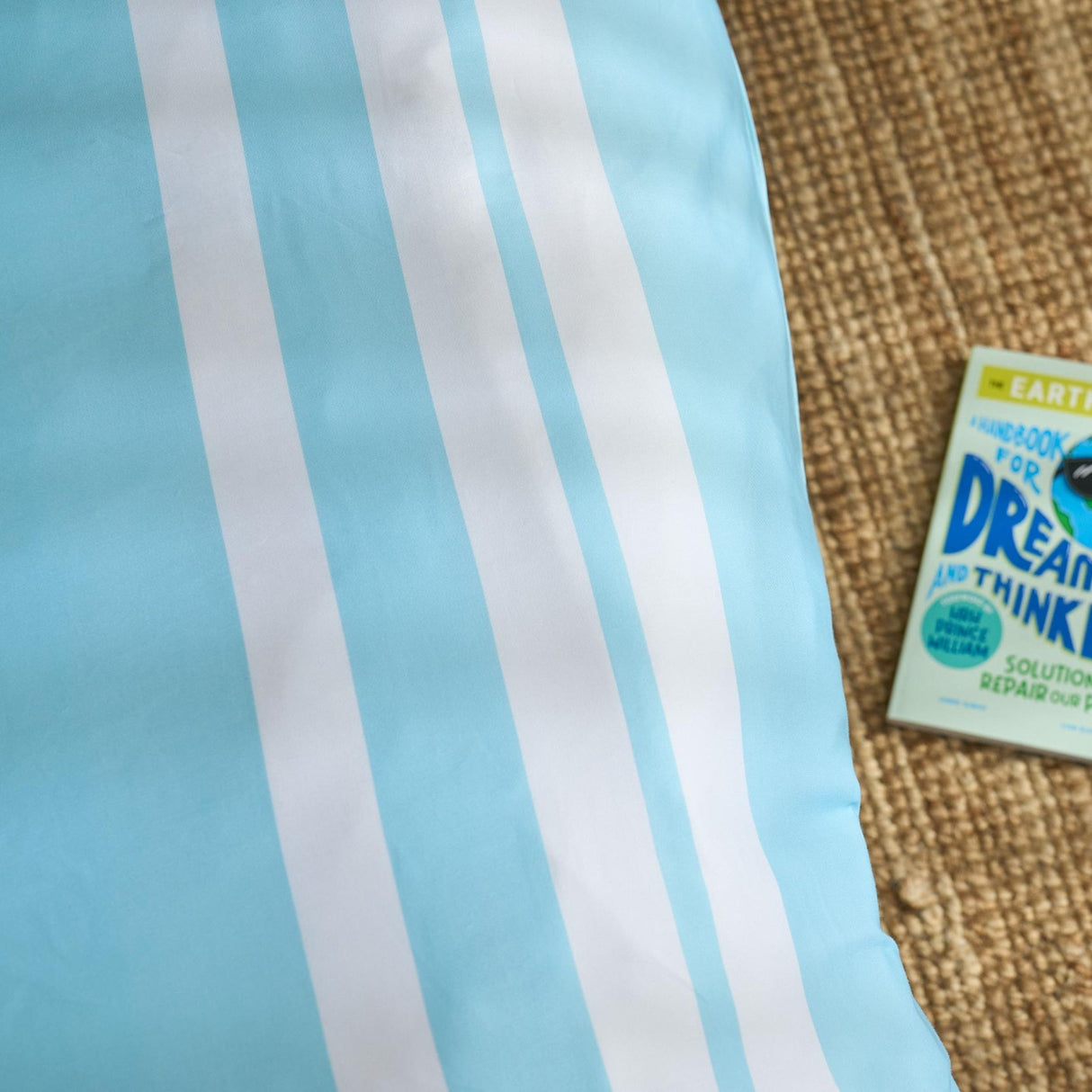 Close-up of a blue and white striped fabric with a book titled 'Dream and Think' on a textured surface.