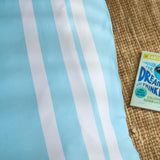 Close-up of a blue and white striped fabric with a book titled 'Dream and Think' on a textured surface.