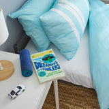 Book titled 'Handbook for Dreamers and Thinkers' on a nightstand next to a bed with blue bedding.