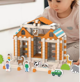 Child playing with a Montesorri toy barn set on a light surface