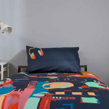 Colorful bedding set with technology themed design on a bed against a plain wall.