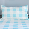 Checkered bedspread with blue and white pattern on a plain background