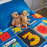Children's math themed quilt with teddy bears and colorful shapes on a bed.