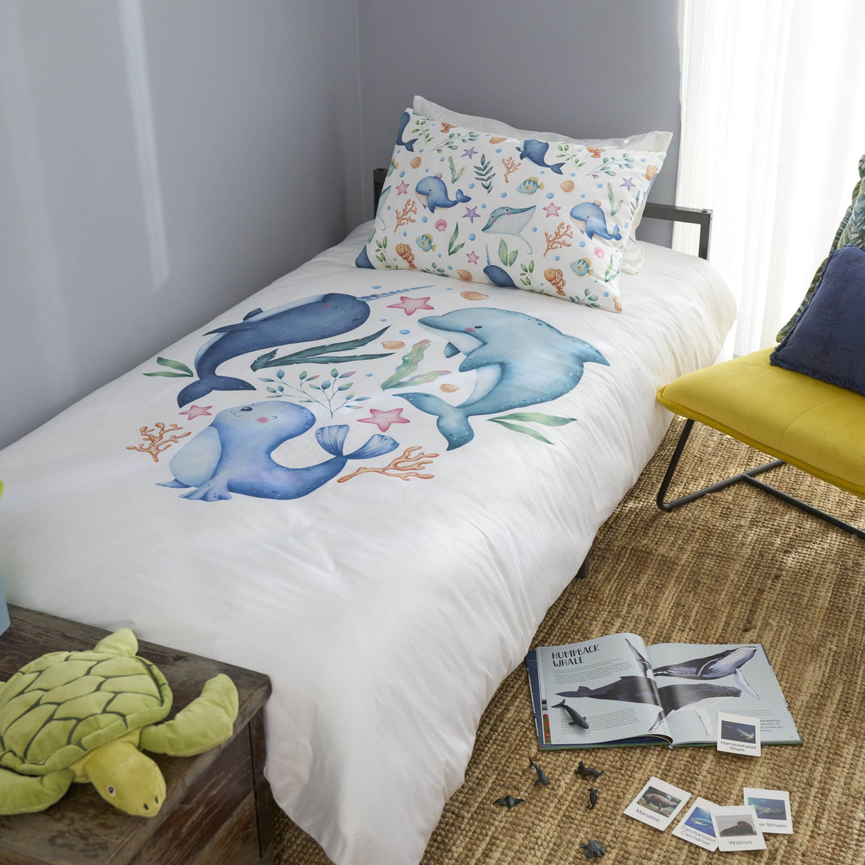 Bedroom with a bed featuring dolphin-themed bedding and pillows.