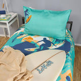 Bedding set with surf design and teal pillow on a bed