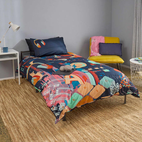 Bedroom with colorful tech themed bedding and a yellow chair.