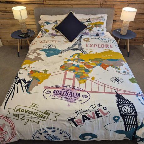 World map-themed bedding set on a bed with decorative pillows in a bedroom setting.